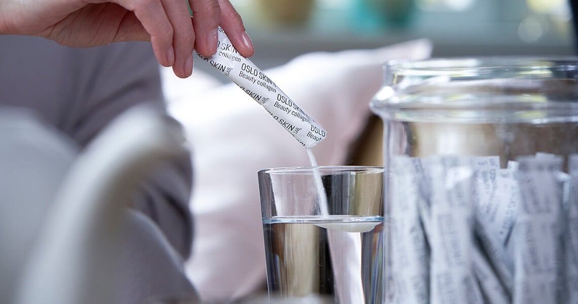 žena si bere pytlíček kolagenu The Solution ze skleněné nádoby 