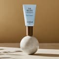 balení očního krému The Recipe Eye Cream stojící na betonové kuličce