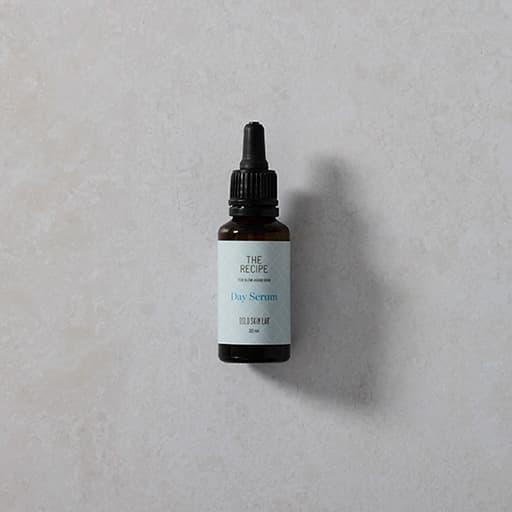 lahvička denního séra The Recipe Day Serum na šedém podkladu