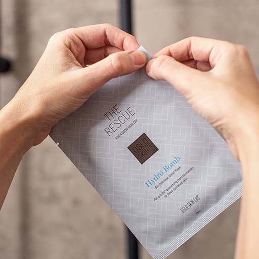 žena drží v ruce balení masky The Hydro Bomb a naznačuje pohybem ruky její otevření