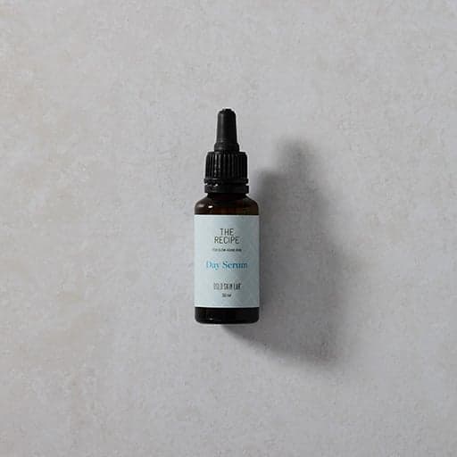 lahvička denního séra The Recipe Day Serum na šedém podkladu